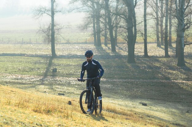 Conquérir les sommets des montagnes par un cycliste en short et maillot sur un vélo semi-rigide en carbone moderne