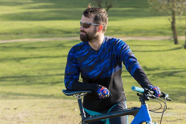 Conquérir les sommets des montagnes par un cycliste en short et maillot sur un vélo semi-rigide moderne en carbone