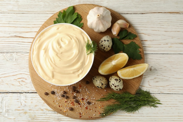 Conseil avec bol de mayonnaise et ingrédients pour la cuisson sur fond de bois