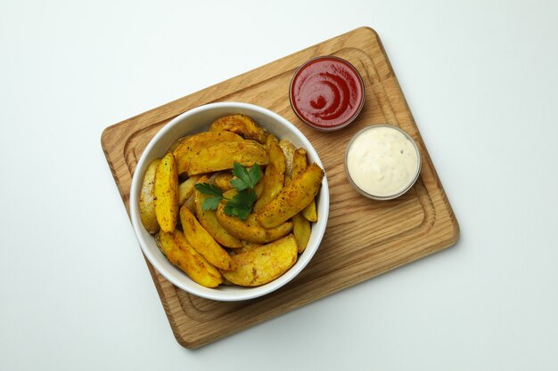 Conseil avec bol de quartiers de pommes de terre et sauces sur blanc