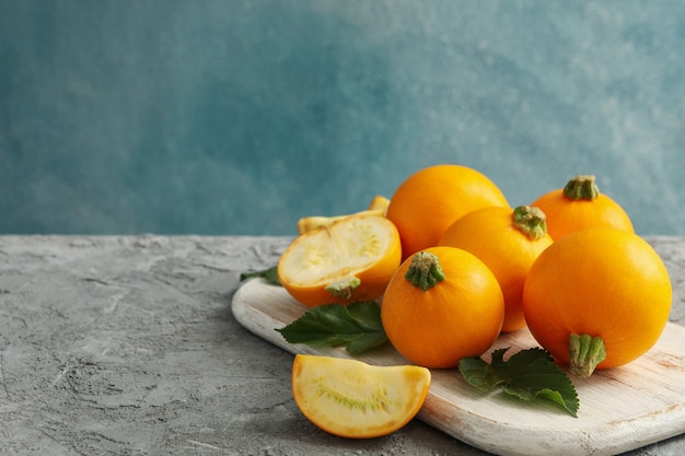 Conseil avec courgettes rondes et feuilles sur gris