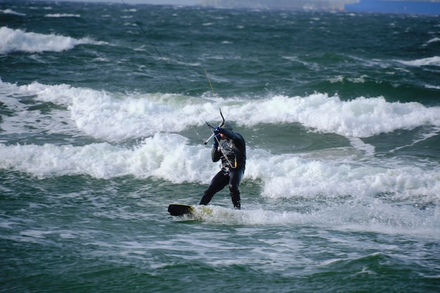 Conseil d'équitation de kitesurf vagues pendant la tempête tenant au cerf-volant