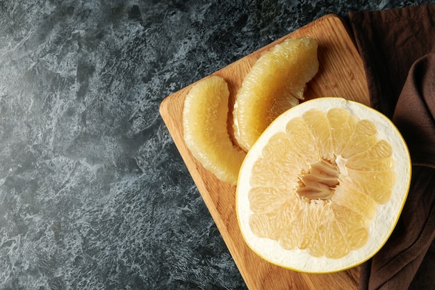 Conseil avec fruits de pomelo mûrs et serviette sur table noire smokey