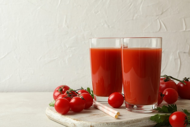 Conseil avec jus de tomate et tomates sur fond texturé blanc