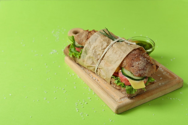 Conseil avec sandwich ciabatta, sauce et sel sur fond vert