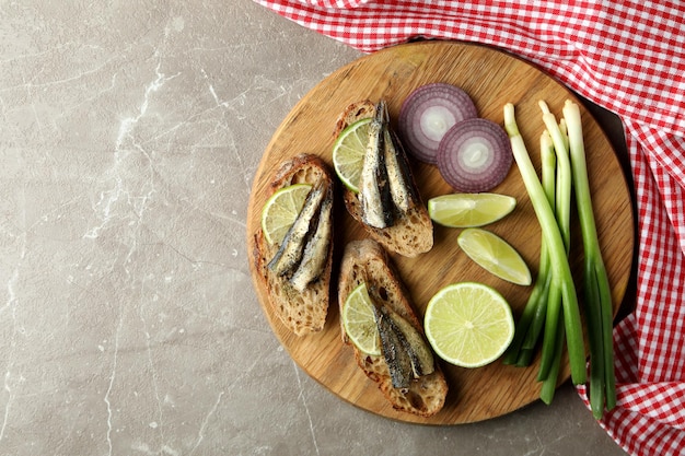 Conseil avec des sandwichs aux anchois sur fond texturé gris