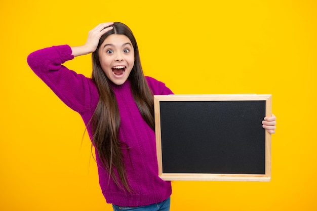 Conseil de vente de l'école Cheerful adolescente kid tenir tableau noir tableau avec copie espace visage excité