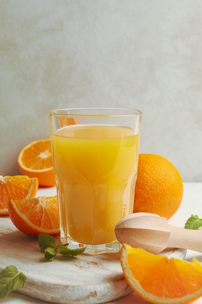 Conseil avec verre de jus d'orange, oranges et presse-agrumes sur table en bois