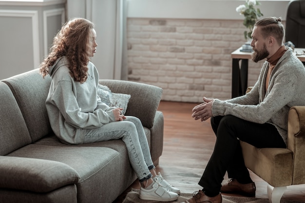 Conseiller après l'école. Belle fille élégante portant un jean et un sweat à capuche gris conseiller de visite après l'école