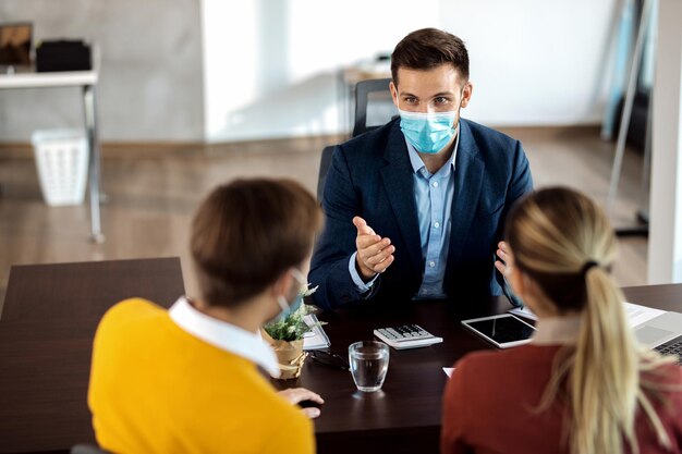 Conseiller financier ayant des consultations avec un couple pendant la pandémie de coronavirus