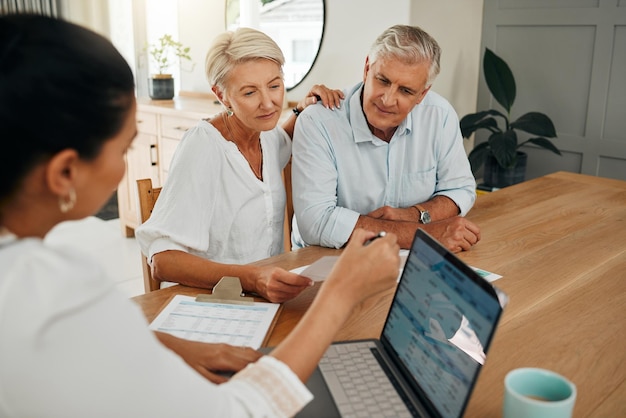 Conseiller financier consultation avec les clients sur la planification du financement de la retraite ou l'investissement et document sur l'écran d'un ordinateur portable