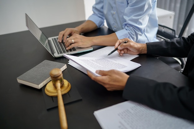 Le conseiller juridique présente au client un contrat signé avec un marteau et un concept de droit juridique, de justice et d'avocat.