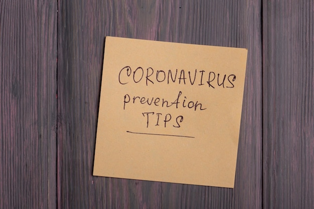 Conseils de prévention du coronavirus texte sur pense-bête sur fond de bois