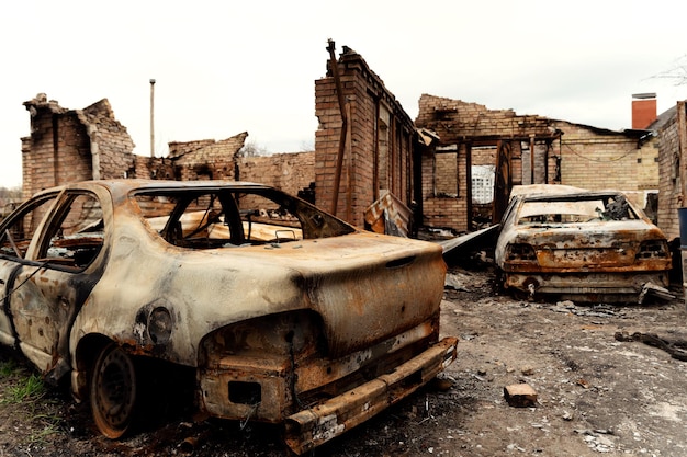 Les conséquences de l'agression militaire de la Russie contre une maison incendiée avec une voiture à bucha et irpen guerre entre la russie et l'ukraine bombardements à la roquette maisons brisées catastrophe en ukraine