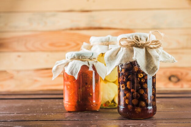 Conserves de légumes sur fond de bois