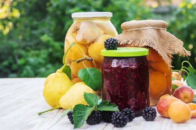 Conserves de poires, abricots et confiture avec des mûres dans des bocaux. Mise au point sélective.