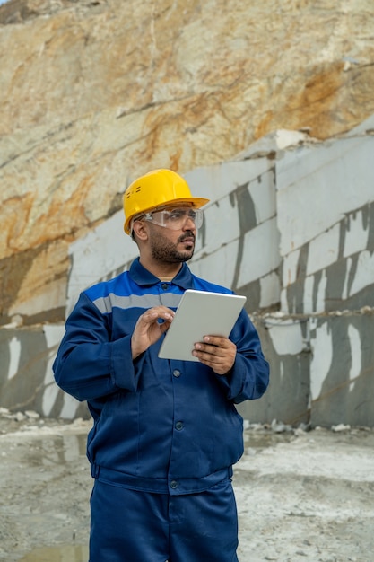 Constructeur d'âge moyen utilisant une tablette au lieu de construction