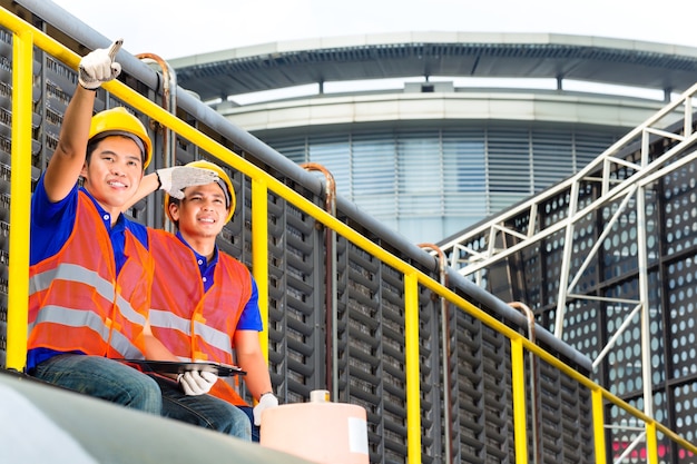 Constructeur asiatique ou techniciens ou ingénieurs sur matériel technique ou site industriel