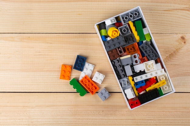 Constructeur fait de cubes en plastique dans une boîte sur la table.