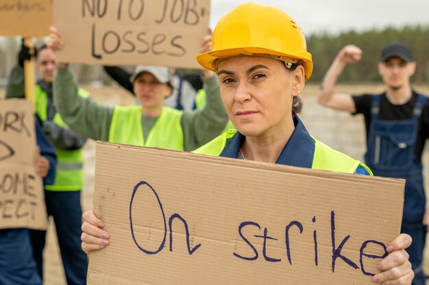 Constructeur féminin d'âge moyen tenant une pancarte pendant la grève