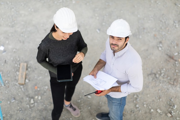 Constructeur et ingénierie sur chantier de construction à la recherche de plans vue de dessus