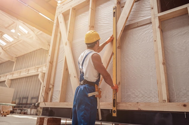 Constructeur masculin dans des combinaisons de travail travaillant au chantier de construction