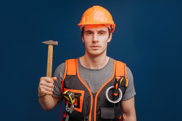 Constructeur sérieux dans un casque avec un marteau