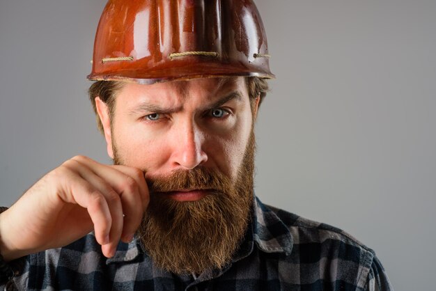 Constructeur de technologie de l'industrie du bâtiment de concept de constructeur dans le portrait de casque d'ouvrier barbu