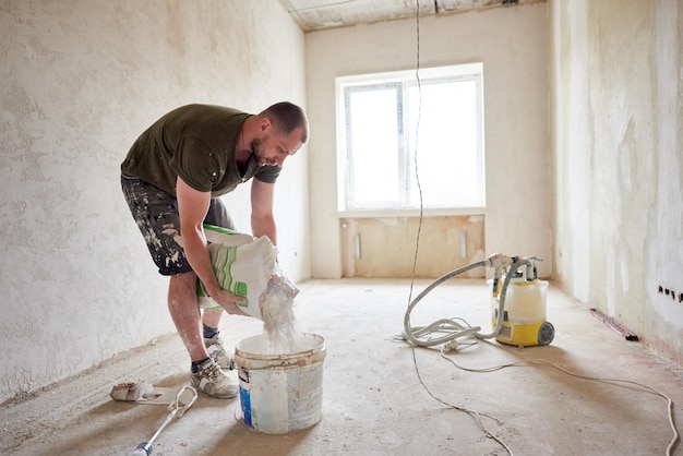 Le constructeur va mélanger le mastic en train de réparer la maison