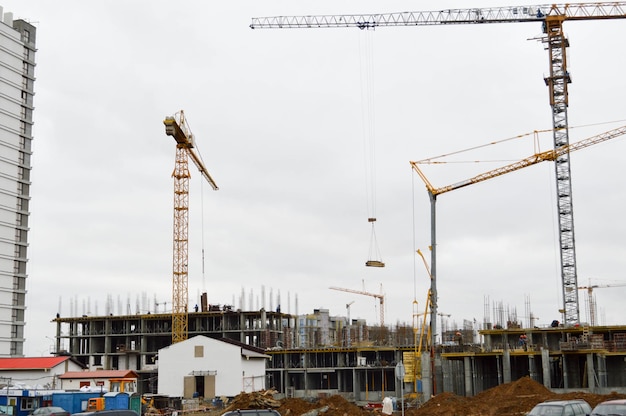 Les constructeurs masculins travaillent sur le toit d'un grand bâtiment de maison à ossature monolithique