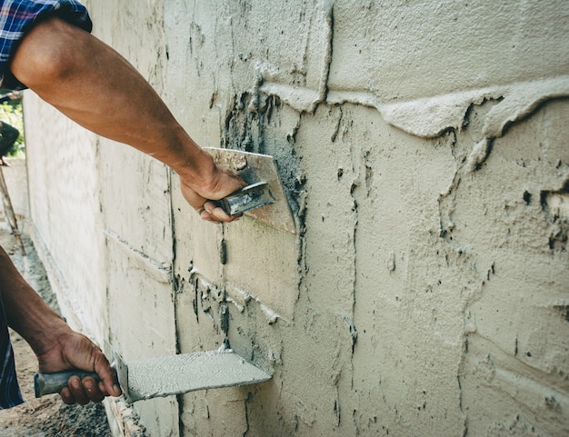 Les constructeurs plâtrent les murs de la maison avec soin.