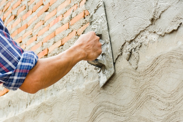 Les constructeurs plâtrent les murs de la maison avec soin.