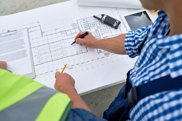 Constructeurs regardant des plans d'étage