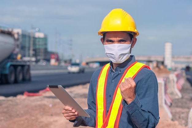 La construction d'un ingénieur asiatique est un employé qui travaille avec un casque de contrôle de sécurité sur le bâtiment du site