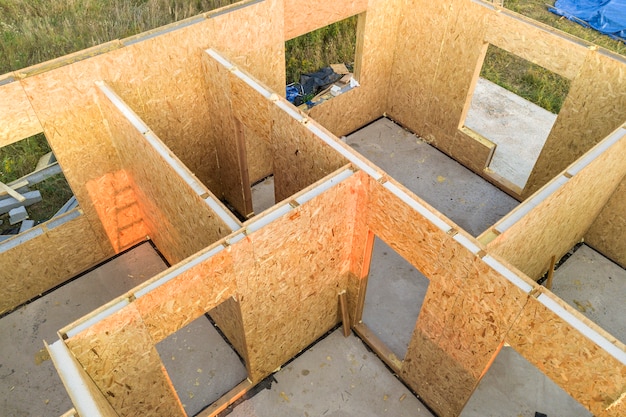 Construction d'une maison modulaire neuve et moderne avec des murs en panneaux de gorgée en bois composite avec isolation en polystyrène à l'intérieur.