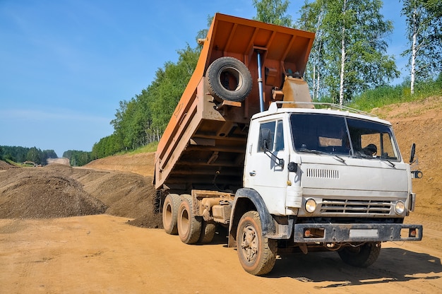 Construction d'une nouvelle route un camion-benne décharge du sable