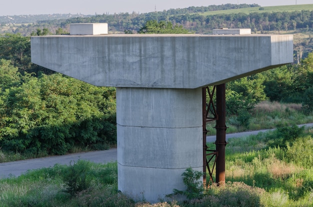 La construction d'un pont sur la rivière avec les supports, les éléments structurels, les grues