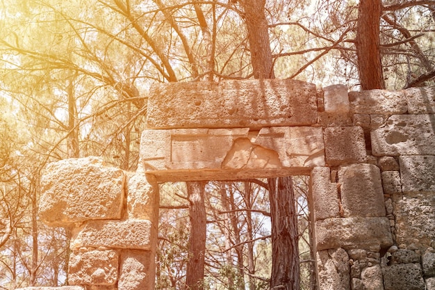 La construction en ruine de l'ancien bâtiment de porte avec des inscriptions en langue ancienne explore les fouilles des ruines de l'ancienne ville lycienne de Phaselis en Turquie en plein air en été