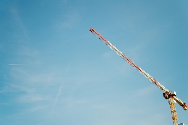 Construire l'avenir ensemble. Espace de copie du ciel de la grue de construction. Architecture et bâtiment. Technologie et industrie. Notion de développement. Grue à tour. Grue à tour haute. Louer du matériel de chantier.