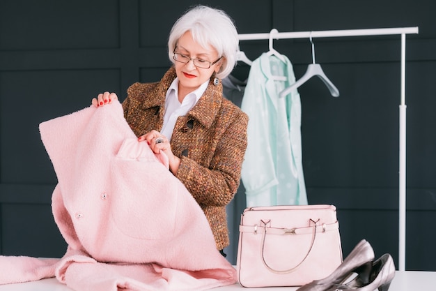 consultante en mode en showroom femme à la mode senior. styliste personnel au travail