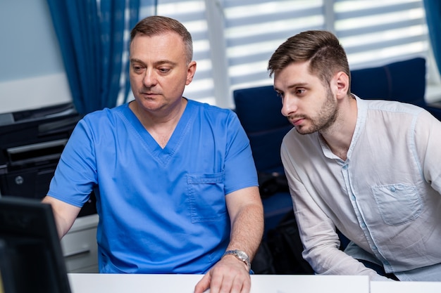 Consultation au cabinet du médecin. Médecin et patient. Affichage des résultats sur ordinateur.