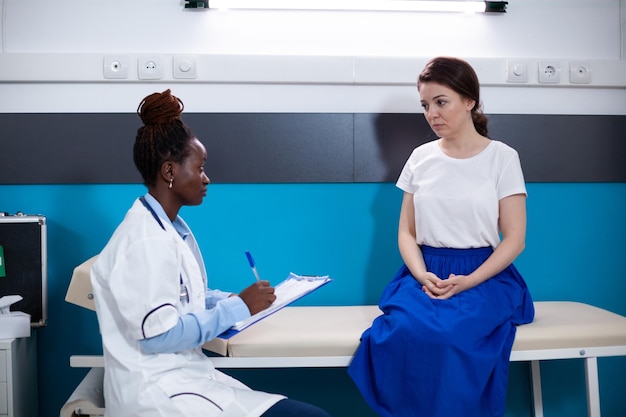 Consultation clinique du patient par un médecin à la recherche de symptômes de maladie et de douleur. Spécialiste de la santé lors d'un examen dans un hôpital moderne offrant un diagnostic au patient