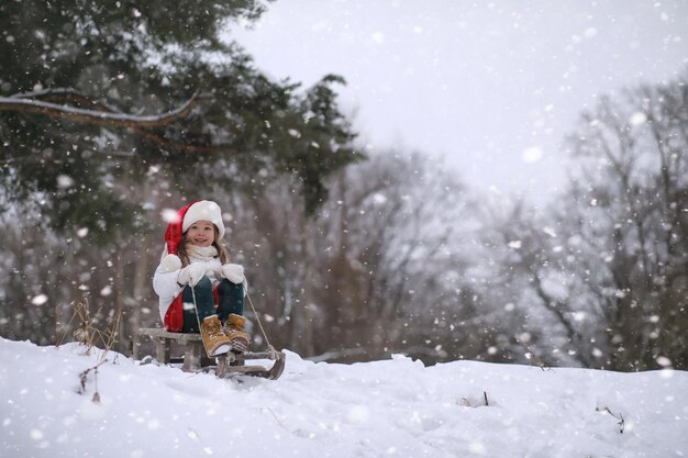 Conte de fées d'hiver une jeune mère et sa fille font du traîneau dans la forêt