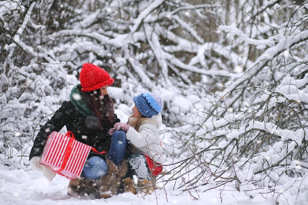 Un conte de fées d'hiver une jeune mère et sa fille font du traîneau dans la forêt