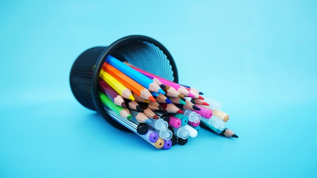 Un contenant de crayons de couleur avec l'inscription "fournitures scolaires" dessus