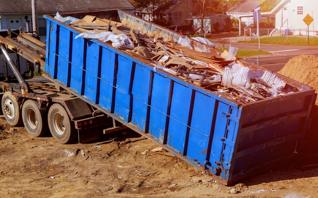 Photo conteneur de débris de construction bleu rempli de gravats de roche et de béton