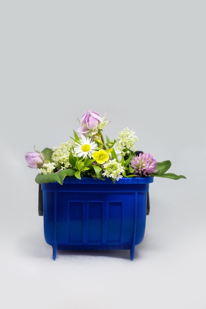 Conteneur de poubelle avec des fleurs, recyclage eco concept