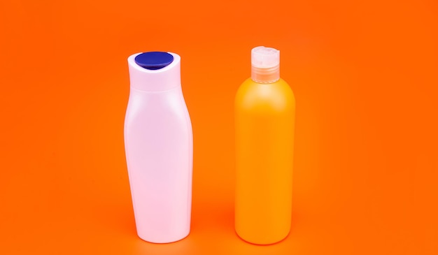 Conteneurs liquides rechargeables HDPE pour produits de toilette cosmétiques espace de copie de fond orange, bouteilles.