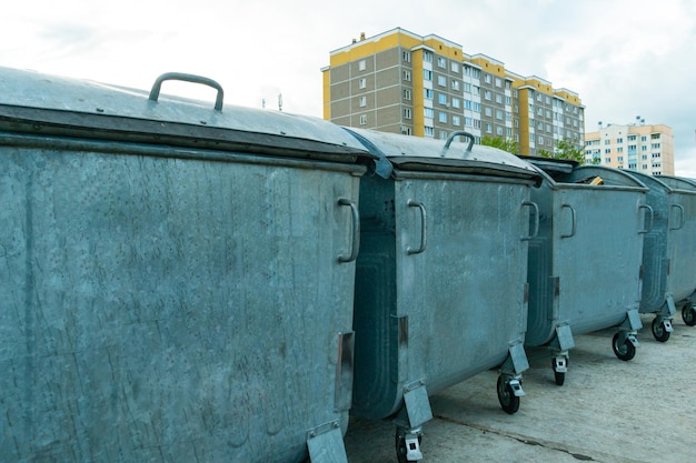 Conteneurs métalliques modernes pour la collecte séparée des ordures Poubelles dans la ville sur le fond d'une maison Problèmes de catastrophe environnementale de la collecte et de l'élimination des déchets dans une grande ville
