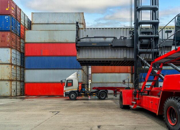 Les conteneurs sont soulevés par chariot élévateur dans le port pour soulever le fourgon sur le camion et le transférer sur un navire de fret